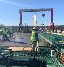 Workers on bridge deck with gantry crane.