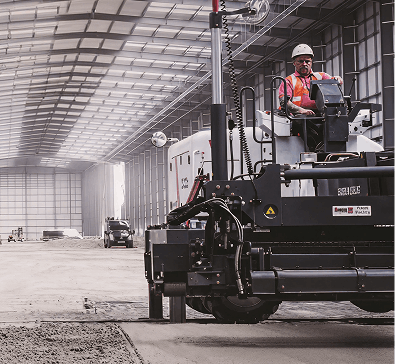 Man is driving machine inside factory.